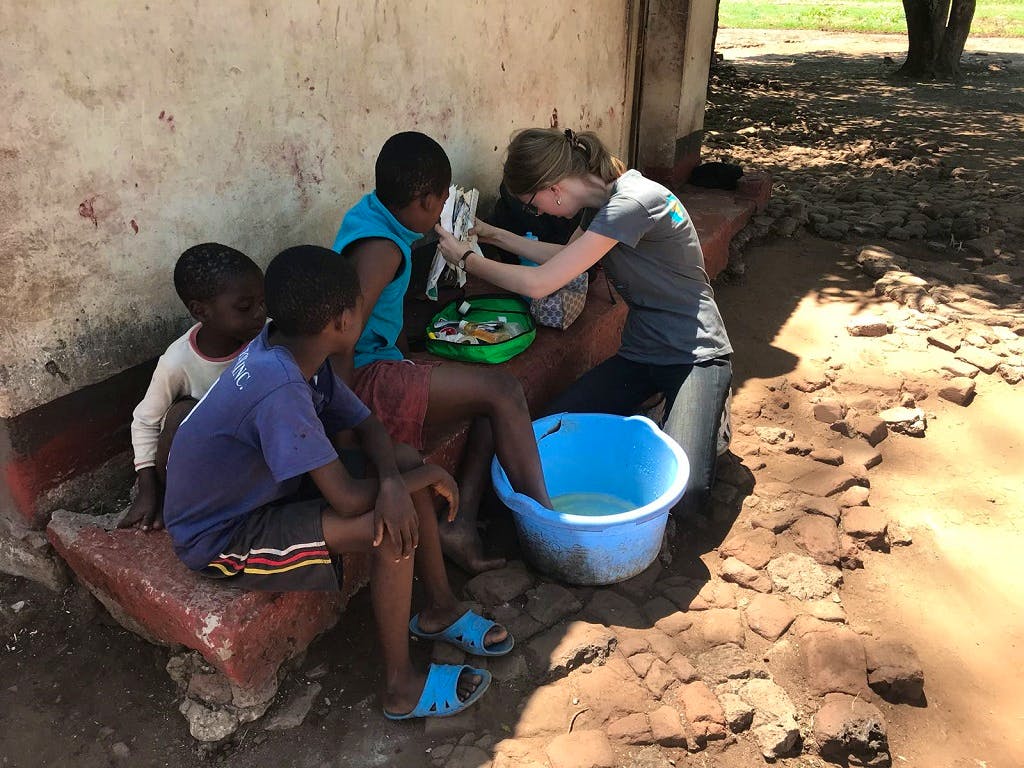 Volunteer cleaning children's wounds