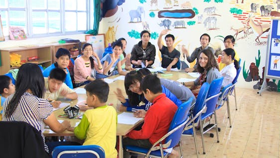 Volunteers and pupils around a table