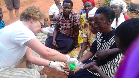 A volunteer teaching women how to wash hands to maintain good hygiene