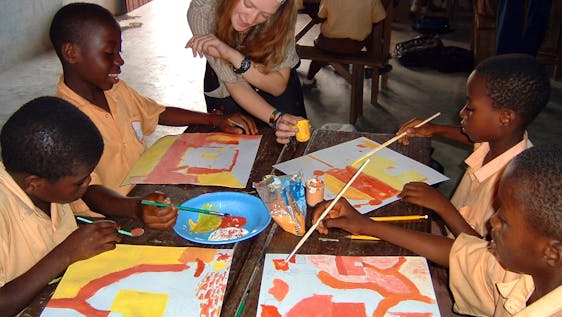 volunteer with kids painting
