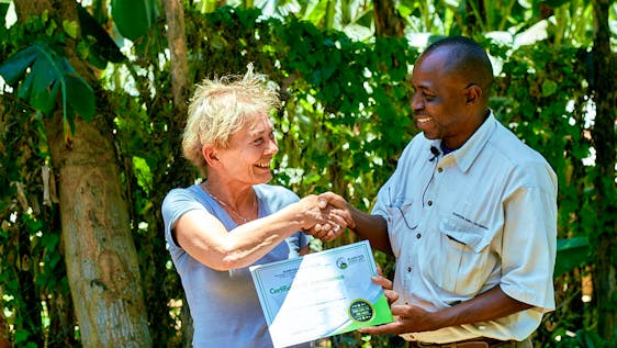 The volunteer is receiving a certificate from the director after completing her voluntary work.